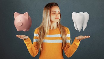 Woman holding up a digital image of a piggy bank and a tooth