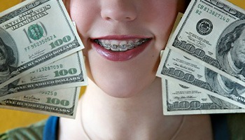 Woman holding a stack of dollar bills up to her face