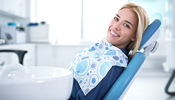 Woman smiling while sitting in dental chair