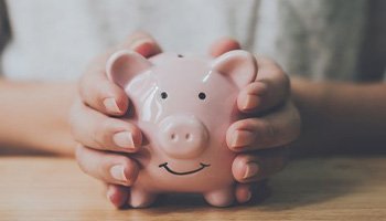 Close up of someone holding their piggy bank