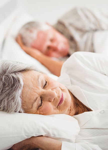 Older couple sleeping peacefully in bed