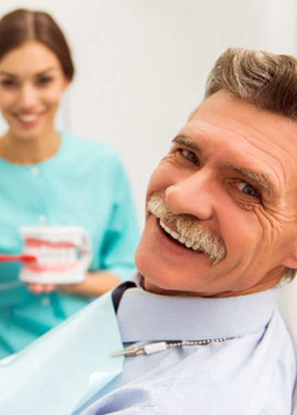 An older man looking at the camera while at the dentist’s office